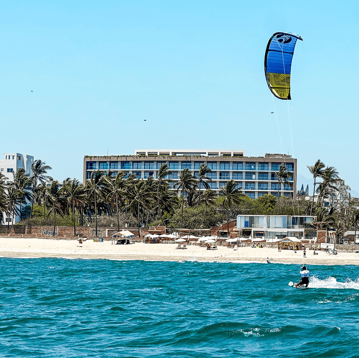 Beach with kitesurfer and resort